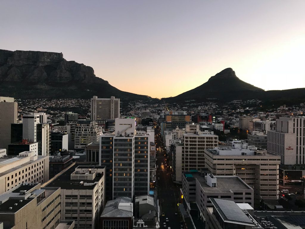 På bilden ser vi utsikt ovanför Kapstaden stad i skymning. I bakgrunden ser vi berget. Hos Liberal Praktik hittar du praktikplatser i Kapstaden